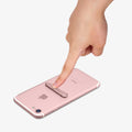 000EM21073 - U100 Universal Kickstand (Metal) in rose gold showing a finger pushing the kickstand attached to device