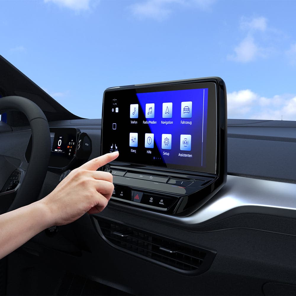 AGL04045 - Volkswagen ID.4 10" Screen Protector EZ FIT GLAS.tR Anti-Glare showing a hand reaching towards the display inside of car