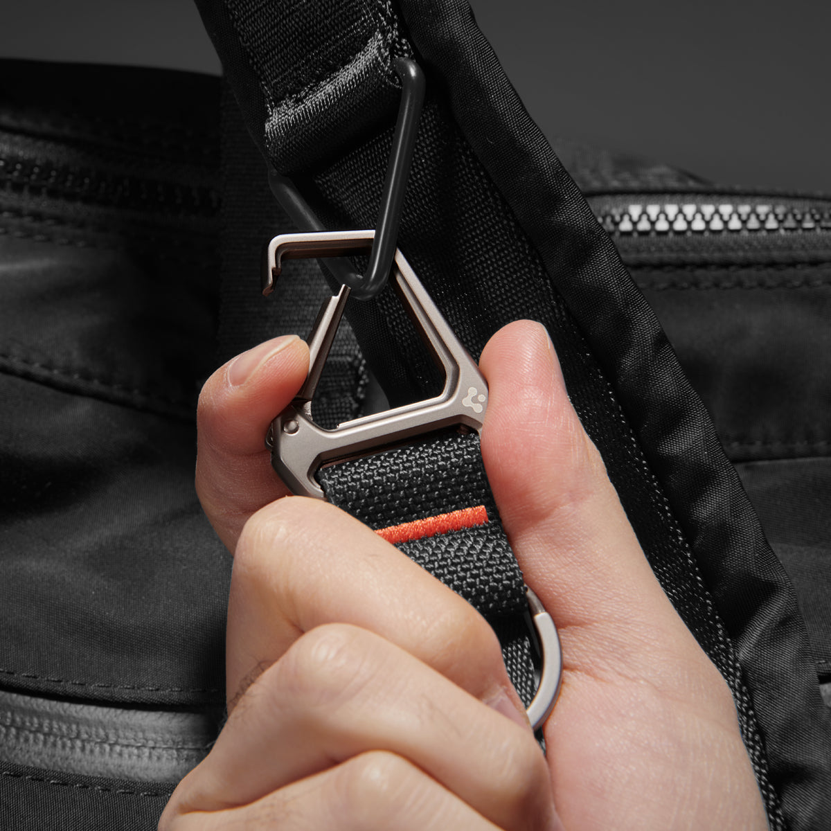 AHP05472 - Carabiner Black Strap + Key Ring showing the carabiner being hooked onto backpack strap