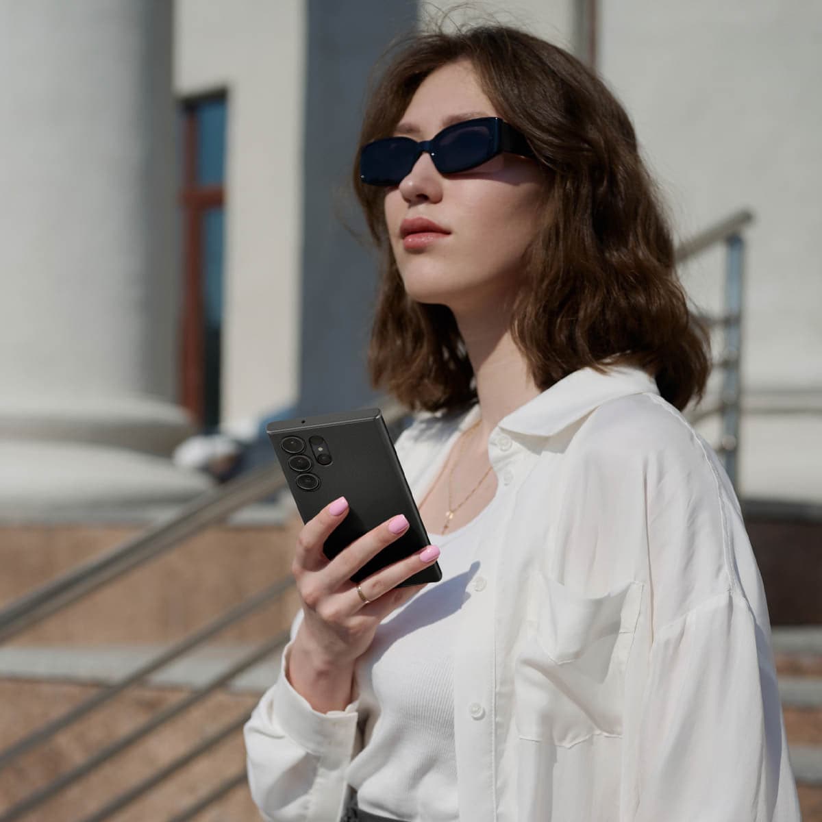 ACS05609 - Galaxy S23 Ultra Case Thin Fit in black showing a woman outside with device in hand